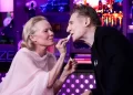 Flirt live në studio! Pamela Anderson “tundon” Liam Neeson me buzëkuqin e saj